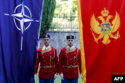 Montenegrin honor guards stand next to NATO and Montenegrin flags during a ceremony in the capital in 2017, the year Podgorica joined the alliance.