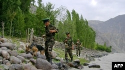 Tajik border guards patrolling the Tajik-Afghan border on the Panj River outside the city of Panj