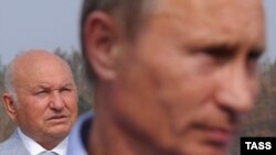 Moscow Mayor Yury Luzhkov (left) looks on as Russian Prime Minister Vladimir Putin faces the media in August.