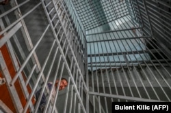 A drug addict looks through bars at an addiction-treatment center in Kabul.