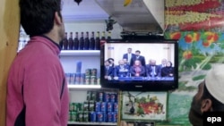 Afghans watch the country's new cabinet being announced on television in Kabul on January 12. For many, the announcement was a huge relief, after months of anxiety.