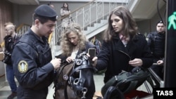 Pussy Riot's Maria Alyokhina (center) and Nadezhda Tolokonnikova (right) enter a court building in Moscow on January 9.