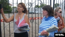 Dzhamilya Dzhakisheva (left) waits with the wives of other Kazatomprom executives to see their husbands at the KNB detention center in Astana.