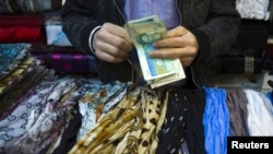 A shopkeeper counts bank notes at a bazaar in Tehran.