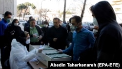 An Iranian lab official registers people for coronavirus testing outside a lab in Tehran on March 9.