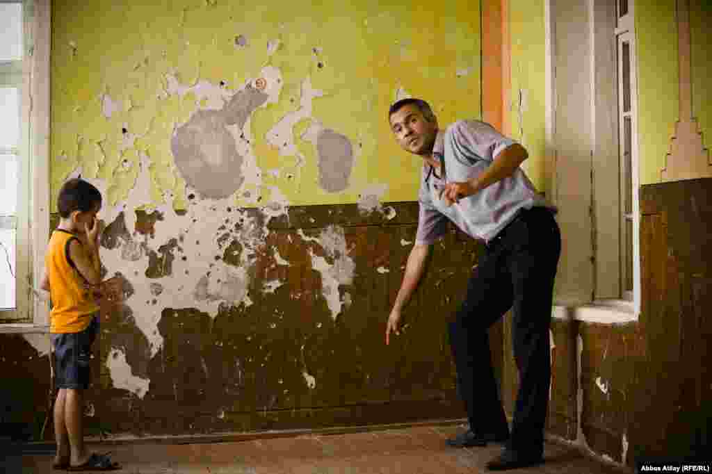 The walls of the house are pock-marked with old bullet holes.