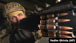 A Ukrainian soldier mans a heavy machine gun at a frontline position in the Luhansk region of eastern Ukraine, where the conflict continues after almost eight years.