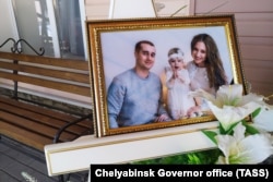 A photo of Igor, Milana, and Anastasia Kramarenko, who died in the collapse, is displayed before a farewell ceremony in Magnitogorsk on January 4.