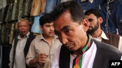 Ramazan Bashardost talks with Afghan men as he campaigns on the streets of Kabul in July.