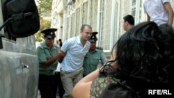 Blogger Emin Milli being taken into court