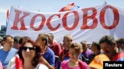 People hold a banner reading "Kosovo" during a protest against the agreement about the normalization of relations between Serbia and Kosovo in Belgrade on May 10.