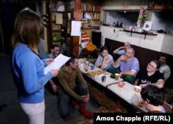 Mikheil Sannikov (center-right) is read a poem at his birthday party in November 2016. The 59-year-old is known as Lama Dokshit to his followers.