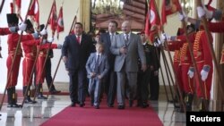 President Hugo Chavez (left) escorts his Belarusian counterpart, Alyaksandr Lukashenka, and the Belarusian president's son, Mykalay, at a welcoming ceremony at Miraflores Palace in Caracas on June 26.