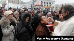 Ukrainians receive sacrament during a gathering organized by supporters of EU integration at Maidan Nezalezhnosti, or Independence Square, in central Kyiv on December 8, with organizers hoping 1 million people will turn out to show their anger over the administration's U-turn on the EU.