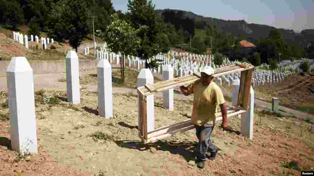 A worker on July 7 prepares graves for a ceremony at the Srebrenica memorial center in Potocari. The International Commission for Missing Persons has so far identified more than 7,000 Srebrenica victims.