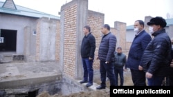 Namangan provincial Governor Shavkat Abdurazzakov (far left) on a visit to the impoverished village of Bunyodkor. 