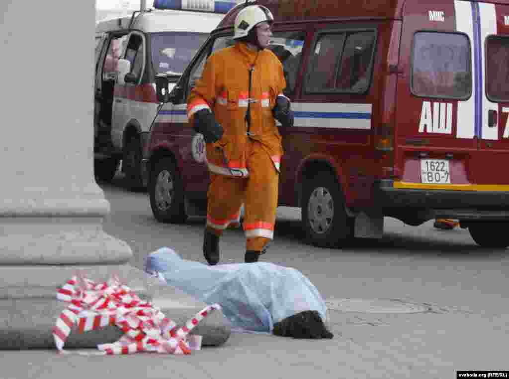 The body of a victim is seen on the ground near the entrance to the subway station.