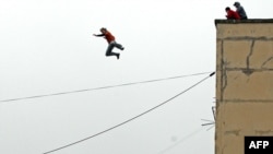 A parkour enthusiast jumps from the roof of an eight-story building to the roof of a five-story building in St. Petersburg.