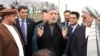 The onus is now on Afghan President Hamid Karzai (center) to stop surrounding himself with former warlords.