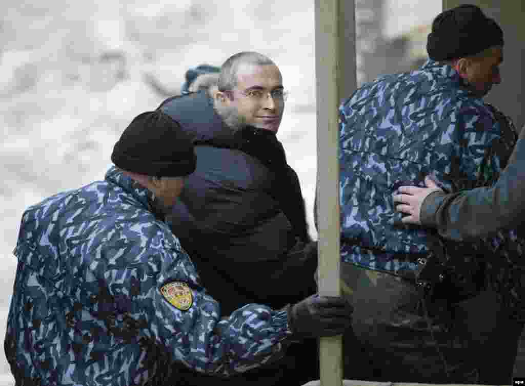 Russian police escort the former Yukos oil chief to a courthouse in Moscow on December 23, 2003.