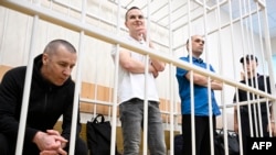 Three lawyers who represented opposition politician Aleksei Navalny: Igor Sergunin (L), Aleksei Liptser (C), and Vadim Kobzev (R) in the defendant's cage.