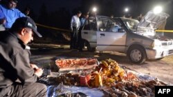 Pakistani security officials search a vehicle found packed with explosives after its seizure by police on the outskirts of Islamabad on April 23.