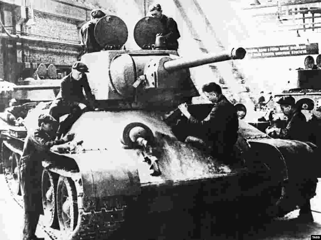 Workers assemble a T-34 tank at the Uralmash Machine-Building Plant during World War II in Sverdlovsk, U.S.S.R., 1942.