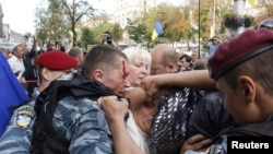 Ukrainian police scuffle amid scuffles as authorities try to restrain supporters of former Ukrainian Prime Minister Yulia Tymoshenko outside the courtroom in Kyiv on August 5, when the judge ordered that Tymoshenko be taken into custody.