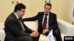 NATO Secretary-General Anders Fogh Rasmussen (right) meets with Georgian President Mikheil Saakashvili, whose party lost the recent elections, during the plenary session of a NATO Parliamentary Assembly in Prague on November 12.