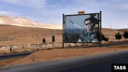 A billboard depicting Syrian President Bashar al-Assad is seen on a road from Damascus to Homs.