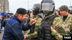 Riot police and a protester face off at a rally earlier this month in Alania Square in Magas against the recent change of borders.