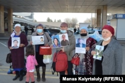 Other Kazakhs hold photos of their relatives trapped in China's Xinjiang region.