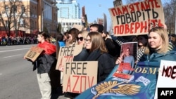 Relatives and friends of Ukrainian prisoners of war from the Azov Brigade hold placards during a rally in the center of Kyiv on March 10 calling for an exchange with Russian prisoners.