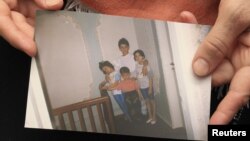 Patimat Suleimanova, an aunt of Boston bombing suspects Dzhokhar and Tamerlan Tsarnaev, holds a family photo at her house in Makhachkala showing the two as young boys .