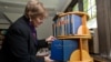 Dean Martha Roth, the editor-in-charge of the Assyrian dictionary, places the final volume to be completed among the others. (photo: University of Chicago -- Jason Smith)