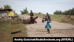 Ten-year-old Davyd rides a mini-quad bike while Stepan tries to catch up. Children are not permitted to go beyond the Luhanske checkpoint.