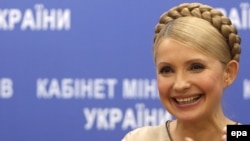 Ukrainian Prime Minister Yulia Tymoshenko smiles as she receives UEFA information at a news conference in Kyiv.