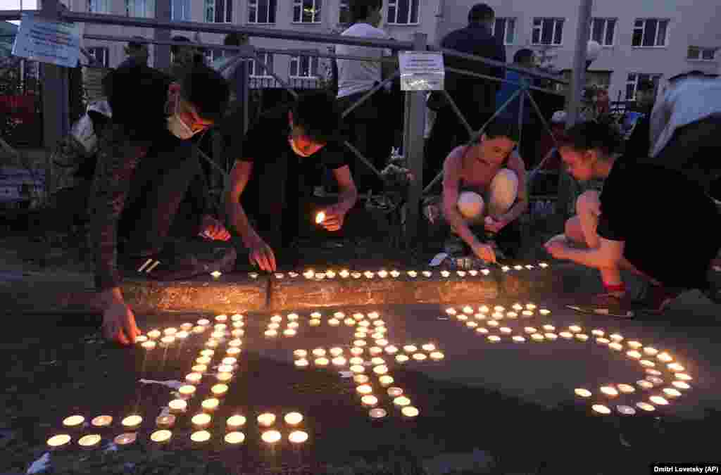 People place lit candles on the ground to form the school&#39;s number 175 in Kazan on May 11.