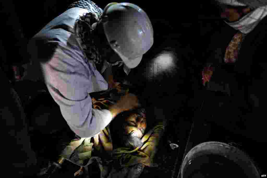 Miners wash the face of a colleague who died in the mine collapse.