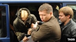 Altyn Deputy Chairwoman Anatonina Babosyuk hides her face as she is escorted to Moscow's Lefortovo court on October 9.