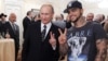 Russian Prime Minister Vladimir Putin (left) poses for a photo with rapper Timati during a meeting with his campaign activists in Moscow in March 2012.