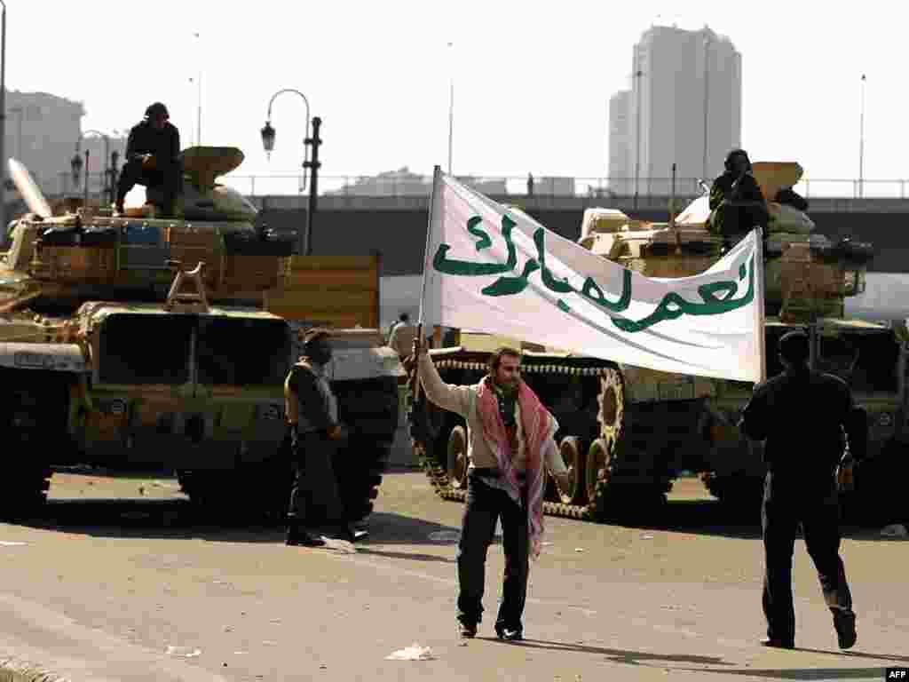 Mubarak supporters hold a banner that says "Yes to Mubarak" during a rally in Cairo.