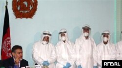 Afghan Health Minister Said Mohammad Amin Fatami speaks at a press conference on November 2 about swine flu. He is surrounded by doctors dressed in full protective suits from a Kabul lab designed to diagnose the H1N1 virus.