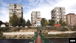 Kosovars cross a foot bridge built by NATO and UN peacekeepers in Mitrovica, one of the flashpoint towns in northern Kosovo.