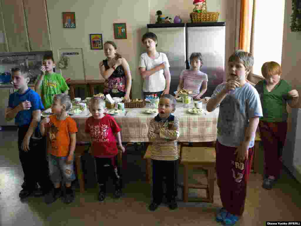 Children pray before dinner.