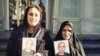 Gohar Eshghi (right) and her daughter hold photos of her son, Sattar Beheshti, who was killed in police custody.