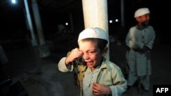 A young student cries after being rescued following a police raid on a madrasah in Karachi on December 12.