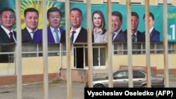 A car drives past a campaign banner in the village of Arashan, some 20 kilometers from Bishkek, on September 30.