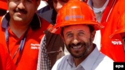 President Ahmadinejad holds a sample of Venezuelan-made synthetic oil during a visit in 2006.