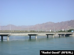 Pedestrians walk across a bridge spanning the Syr Darya River in Khujand. (file photo)